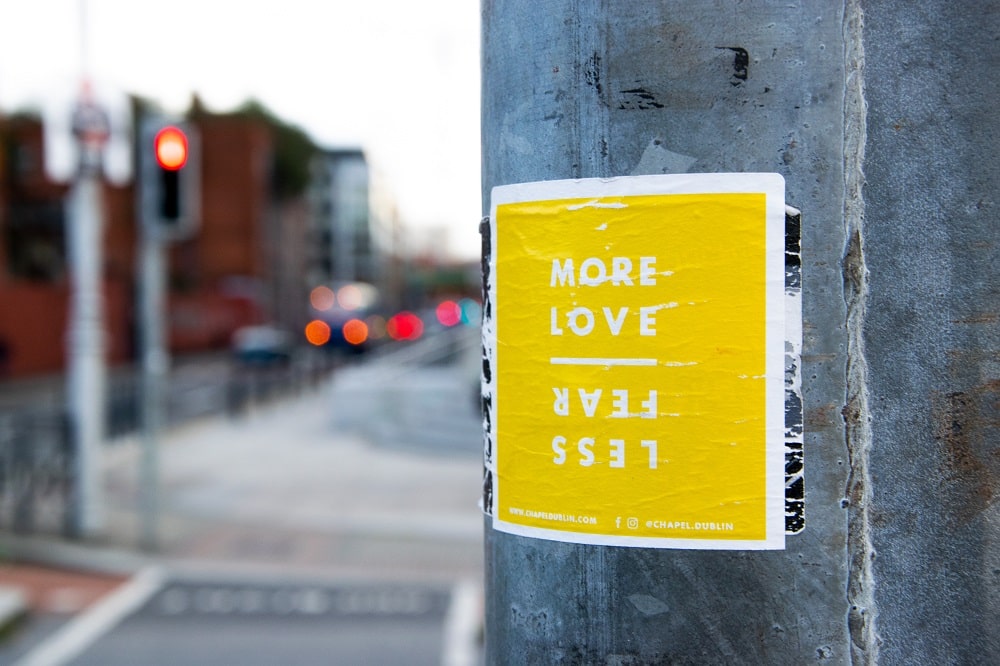More-Love-Less-Fear-Yellow-Sticker-On-Lampost-traffic lights