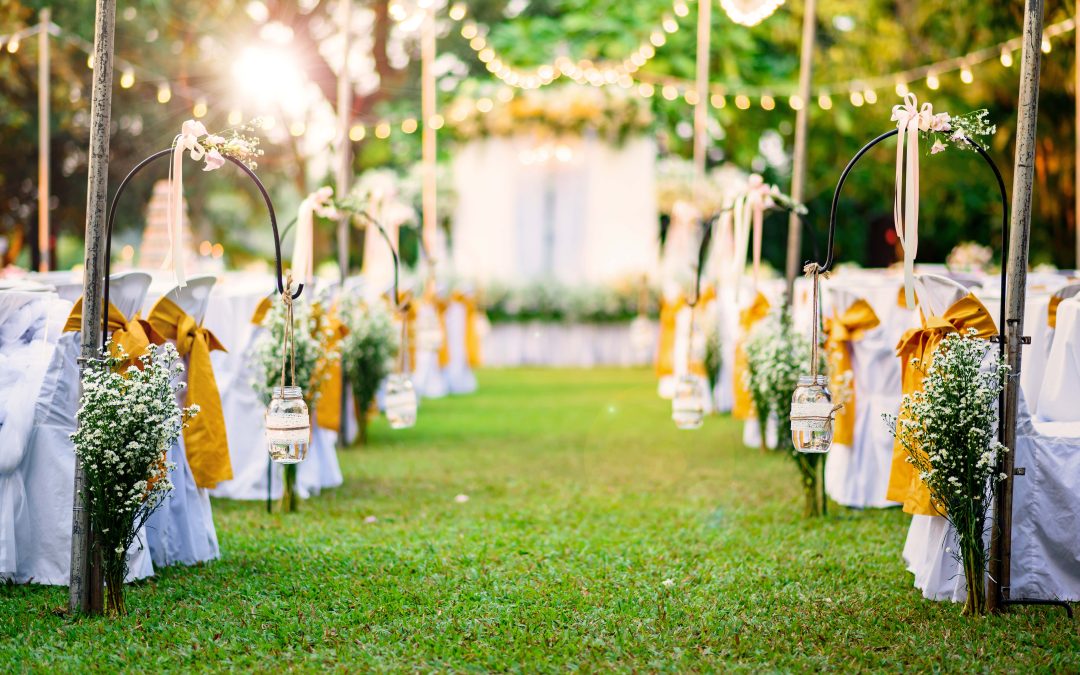 Grass-aisle-white-wedding-chairs-yellow-ribbons-outdoors