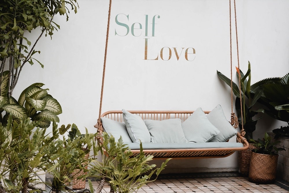 Self-Love-Garden-Swing-White'Walls-Cushions-Plants